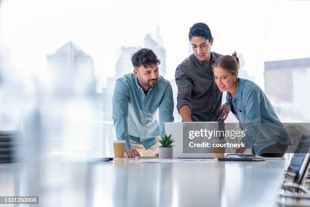 business team working on a laptop computer. - three people stock pictures, royalty-free photos & images