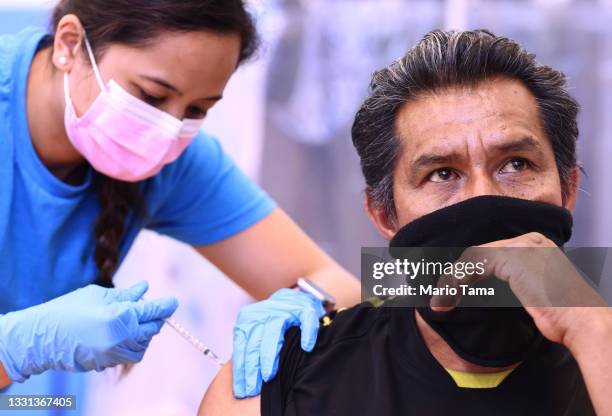 Registered nurse Darryl Hana administering a dose of the Pfizer COVID-19 vaccine to a person at a three-day vaccination clinic at Providence...