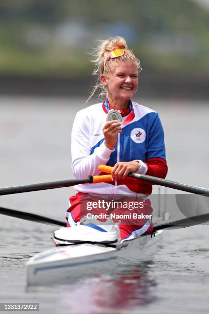 Silver medalist Hanna Prakatsen of Team ROC poses with her medal on her boat after the Women's Single Sculls Final A on day seven of the Tokyo 2020...