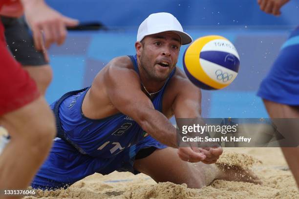 Adrian Ignacio Carambula Raurich of Team Italy dives for the ball against Team Switzerland during the Men's Preliminary - Pool C beach volleyball on...