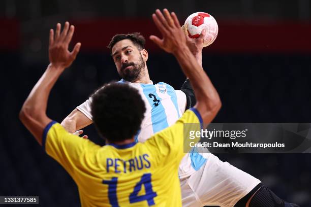 Federico Pizarro of Team Argentina shoots at goal as Thiagus Petrus of Team Brazil defends during the Men's Preliminary Round Group A handball match...