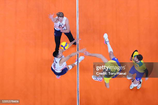 Lucas Saatkamp of Team Brazil strikes against Micah Christenson of Team United States and Maxwell Holt during the Men's Preliminary Round - Pool B...