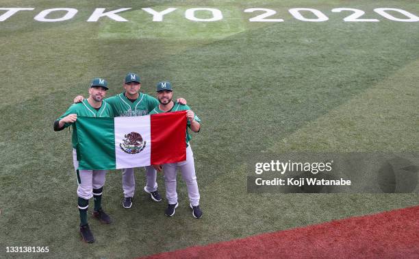 Oliver Perez, Manuel Banuelos and Manuel Barrera of Team Mexico hold up a Mexican flag before the game against Team Dominican Republic during the...