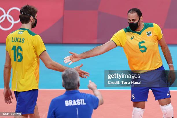 Lucas Saatkamp of Team Brazil high-fives Mauricio Borges Almeida Silva while wearing face masks during the Men's Preliminary Round - Pool B...