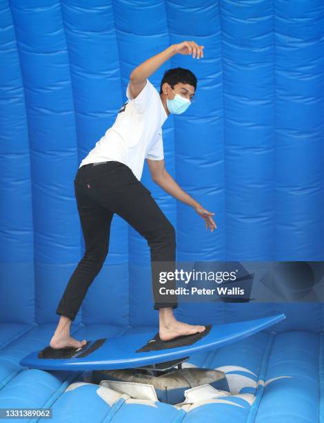 Sports fan tries a surfing activation during the Tokyo 2020 Olympic Games at the Brisbane Live site at South Bank on July 30, 2021 in Brisbane,...