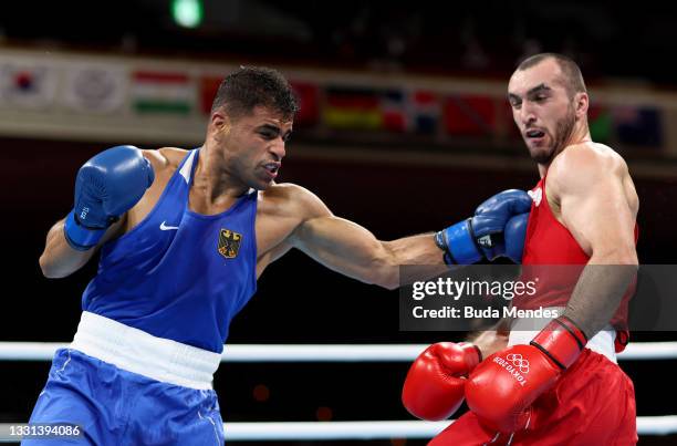 Muslim Gadzhimagomedov of Team Russian Olympic Committee exchanges punches with Ammar Riad Abduljabbar of Team Germany during the Men's Heavy quarter...