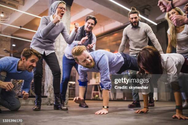 wheelbarrow race on a break in the office! - businesswoman handstand stock pictures, royalty-free photos & images