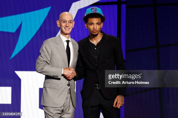 Commissioner Adam Silver and James Bouknight pose for photos after Bouknight was drafted by the Charlotte Hornets during the 2021 NBA Draft at the...