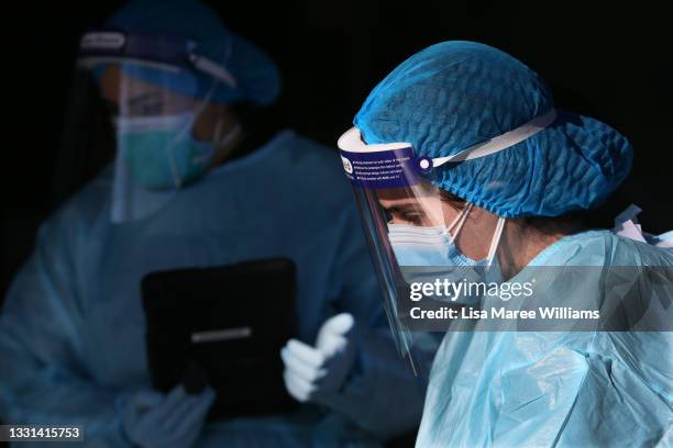 Medical staff assist locals queueing at a medical centre to undertake COVID-19 testing in the district of Fairfield on July 30, 2021 in Sydney,...