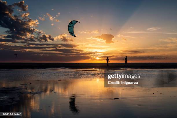 silhouette of two kitesurfers at sunset, los lances beach, tarifa, cadiz province, andalusia, spain - tarifa stock pictures, royalty-free photos & images