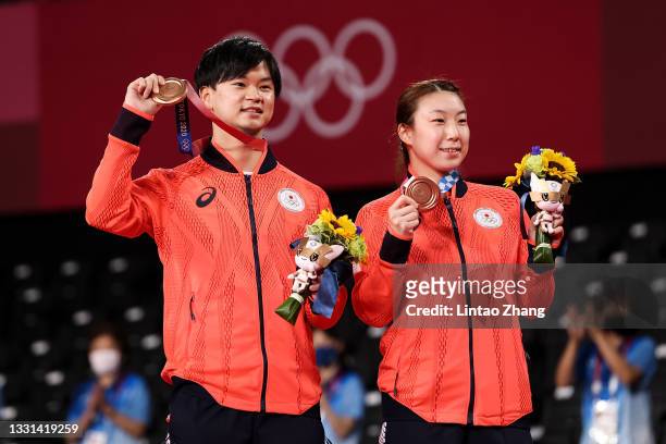 Bronze medalists Yuta Watanabe and Arisa Higashino of Team Japan pose on the podium during the medal ceremony for the Mix Doubles badminton event on...