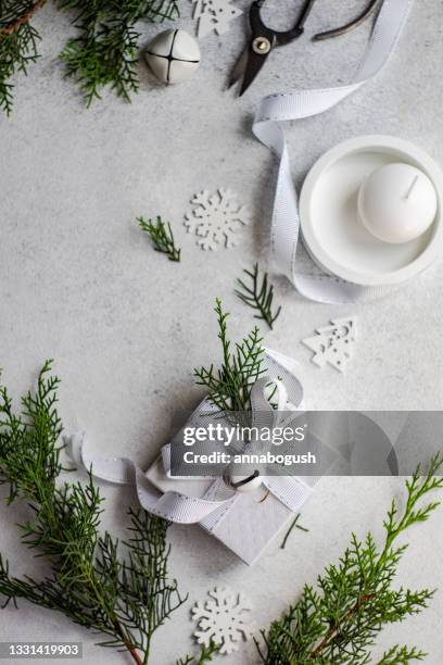 overhead view of a wrapped christmas gift with rustic thuja foliage decoration next to a candle - candle overhead stock-fotos und bilder