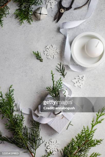 overhead view of a wrapped christmas gift with rustic thuja foliage decoration next to a candle - candle overhead stock pictures, royalty-free photos & images