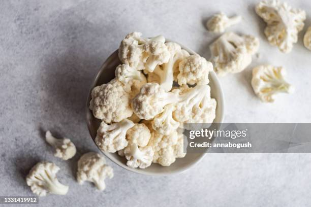 overhead view of a bowl of cauliflower florets - cauliflower bowl stock pictures, royalty-free photos & images