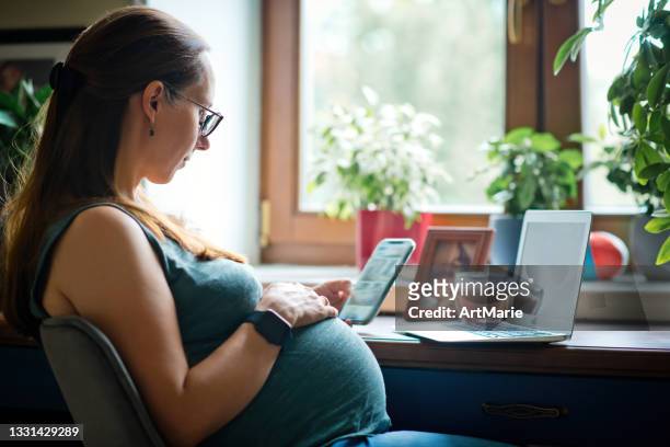 pregnant woman working from home - pregnancy class stockfoto's en -beelden