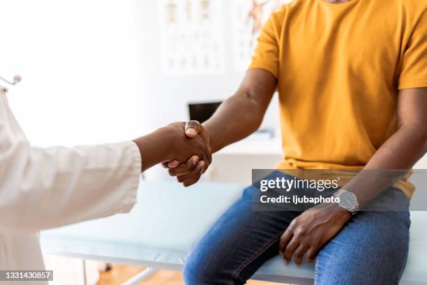 female therapist shakes hands with new male patient - afkickcentrum stockfoto's en -beelden