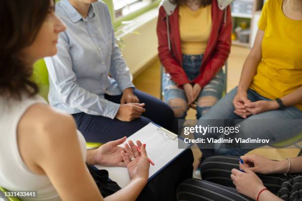 una sesión de terapia de grupo en un consultorio psicológico. - desintoxicación fotografías e imágenes de stock