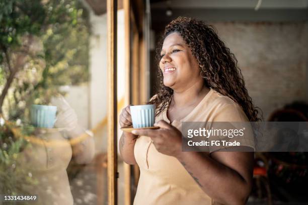 mature woman drinking tea and contemplating at home - generation x stock pictures, royalty-free photos & images