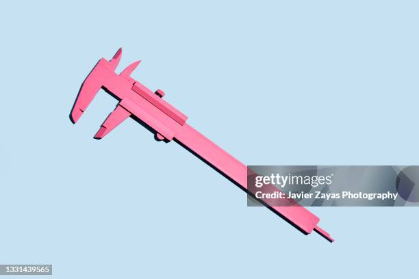 pink vernier gauge calliper on blue background - calibrador fotografías e imágenes de stock