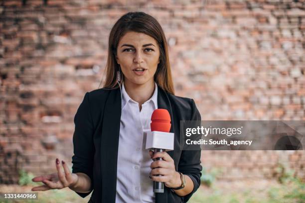 female reporter talking in front of the camera live in news - journalist imagens e fotografias de stock