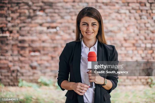 reporter donna che parla davanti alla telecamera in diretta nelle notizie - journalist foto e immagini stock