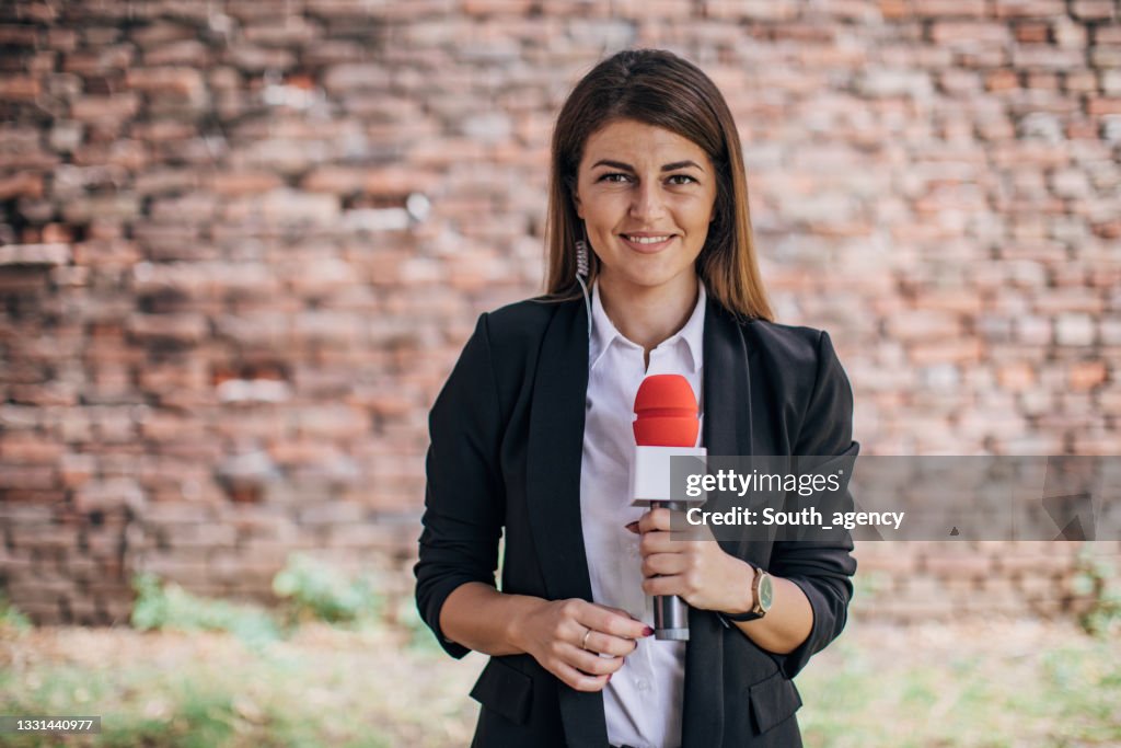 Female reporter talking in front of the camera live in news