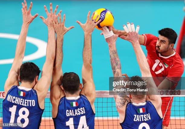 Meisam Salehi of Team Iran competes against Alessandro Michieletto, Gianluca Galassi and Ivan Zaytsev of Team Italy during the Men's Preliminary...