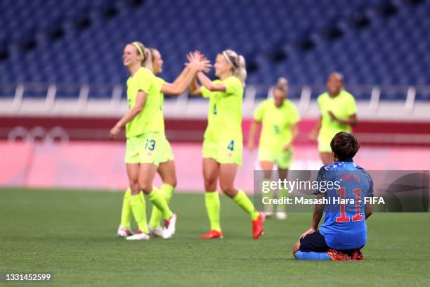 Mina Tanaka of Team Japan looks dejected as players of Team Sweden celebrate after victory in the Women's Quarter Final match between Sweden and...