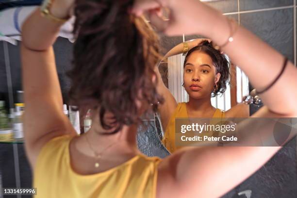 woman tying hair up - combing foto e immagini stock