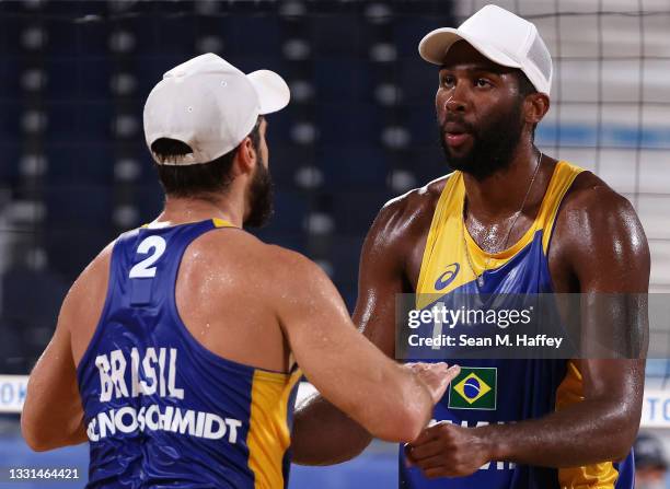 Evandro Goncalves Oliveira Junior and Bruno Oscar Schmidt of Team Brazil react against Team Poland during the Men's Preliminary - Pool E beach...