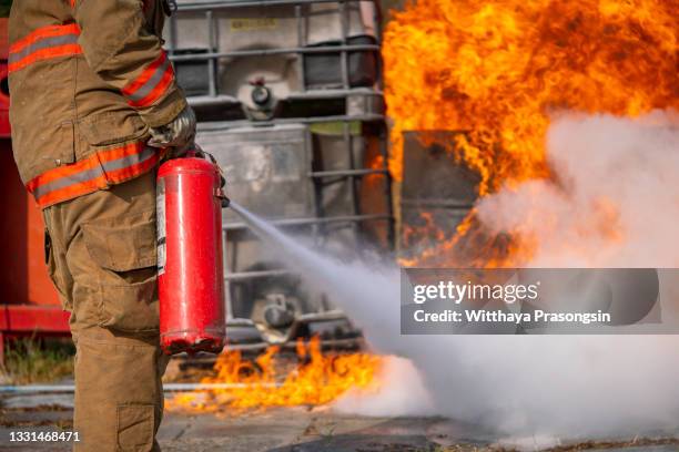 concept man using fire extinguisher fighting fire closeup - fire extinguisher inspection stock pictures, royalty-free photos & images