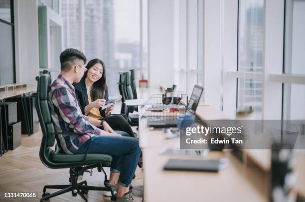 side view  asian chinese female colleague explaining to her trainee  having discussion at office workplace - apprenticeship stock pictures, royalty-free photos & images