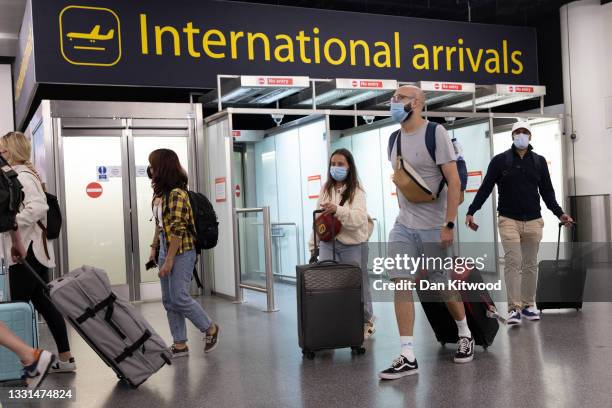 Travelers arrive at Gatwick Airport on July 30, 2021 in London, England. Restrictions to and from the UK remain in place as Coronavirus continues to...