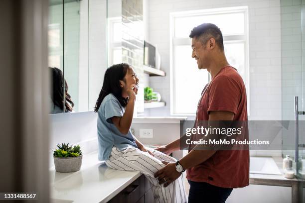 father helping daughter brush her teeth - lavarse los dientes fotografías e imágenes de stock