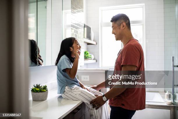 father helping daughter brush her teeth - brushing teeth stock pictures, royalty-free photos & images
