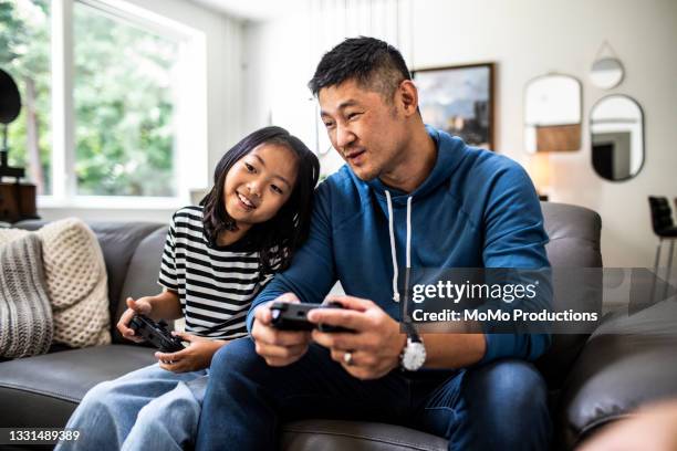 father and daughter playing video games at home - father and daughter play imagens e fotografias de stock