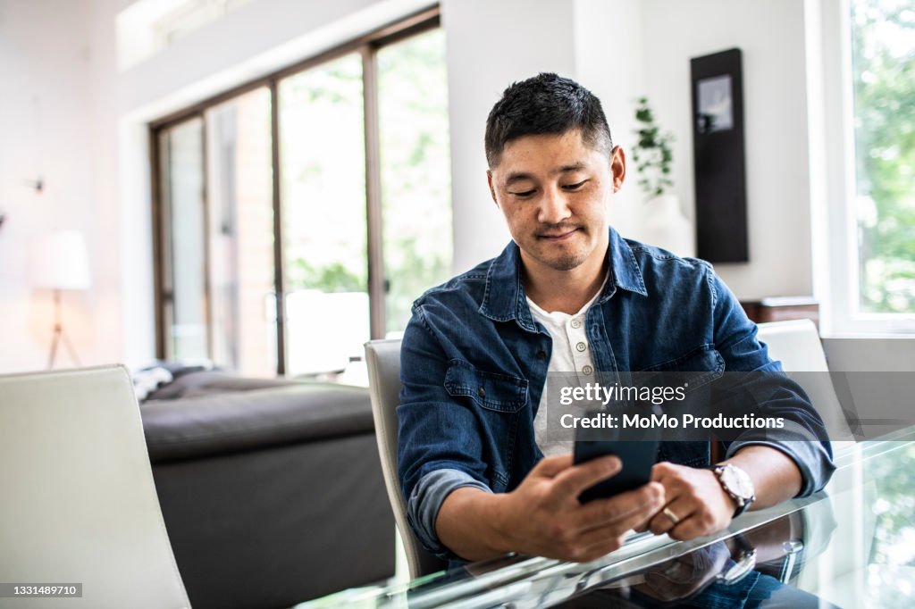 Someone Using Mobile Device Man Using Mobile Device At Home Foto stock - Getty Images