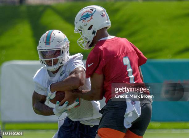Quarterback Tua Tagovailoa hands the ball to Running Back Myles Gaskin of the Miami Dolphins during Training Camp at Baptist Health Training Complex...