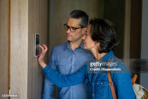 couple leaving their house and locking the door using a home automation system - abrir a porta sair imagens e fotografias de stock