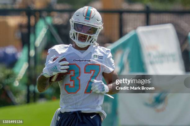 Running Back Myles Gaskin of the Miami Dolphins runs with the ball during Training Camp at Baptist Health Training Complex on July 30, 2021 in Miami...