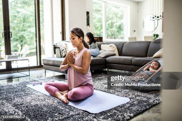 mother doing yoga at home surrounded by children - adult male vest exercise stock pictures, royalty-free photos & images