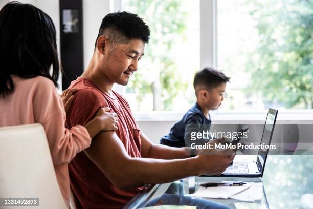 father working from home while distracted by children - asian smiling father son stock pictures, royalty-free photos & images