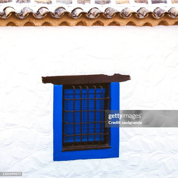 window painted in blue against white wall - castilla la mancha stock-fotos und bilder