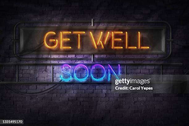 get well soon in neon lights against brick wall - get well card stockfoto's en -beelden