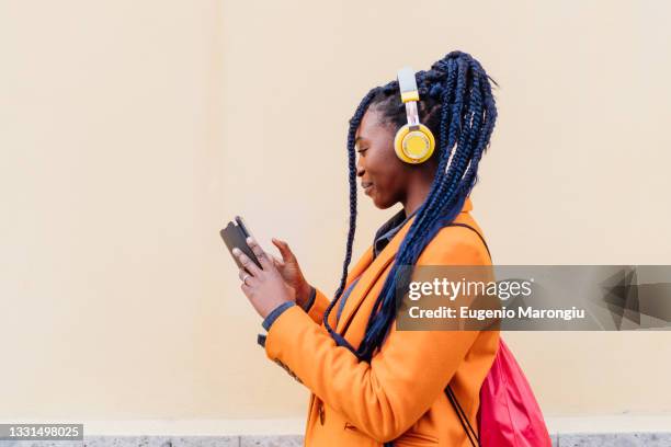 italy, milan, woman with headphones and smart phone outdoors - headphones woman stock pictures, royalty-free photos & images