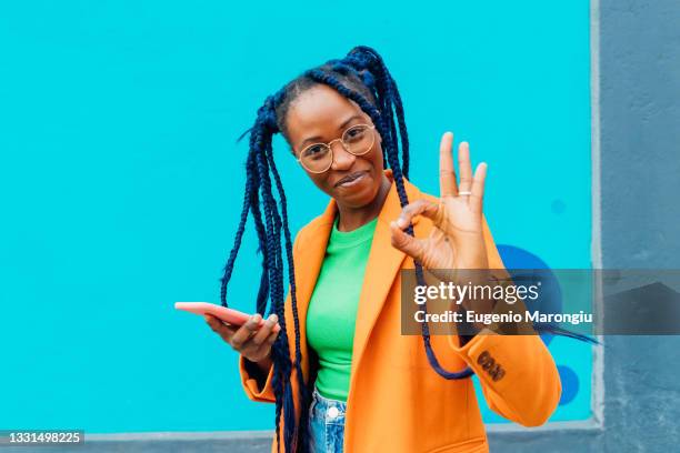 italy, milan, woman with braids making okay sign - self satisfaction stock pictures, royalty-free photos & images