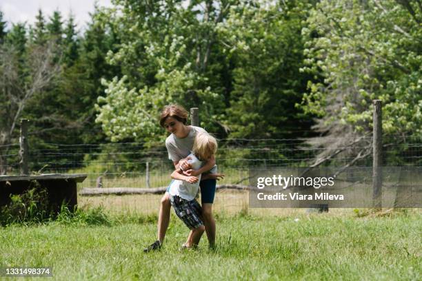 canada, ontario, kingston, boys (8-9, 14-15) play fighting outdoors - taquiner photos et images de collection