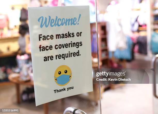 Sign requiring mask use is seen outside of a store in Union Station on July 30, 2021 in Washington, DC. DC Mayor Muriel Bowser restored a COVID-19...