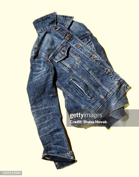 denim jean jacket on a bright yellow background - denim jacket foto e immagini stock