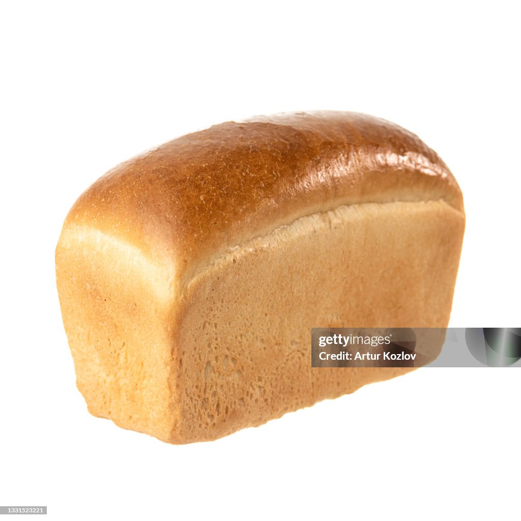 Golden wheat brick shaped bread bread. Whole loaf of bread isolated on white background